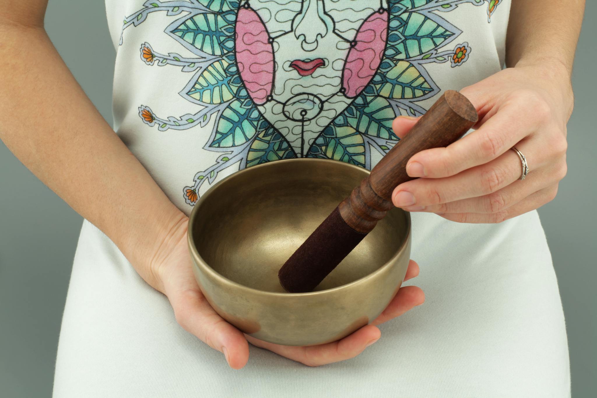 Close-up of hands holding a Tibetan singing bowl for meditation and relaxation.